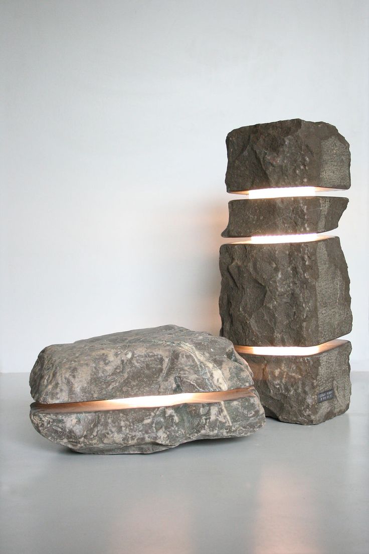 three large rocks are stacked on top of each other, with one light at the end