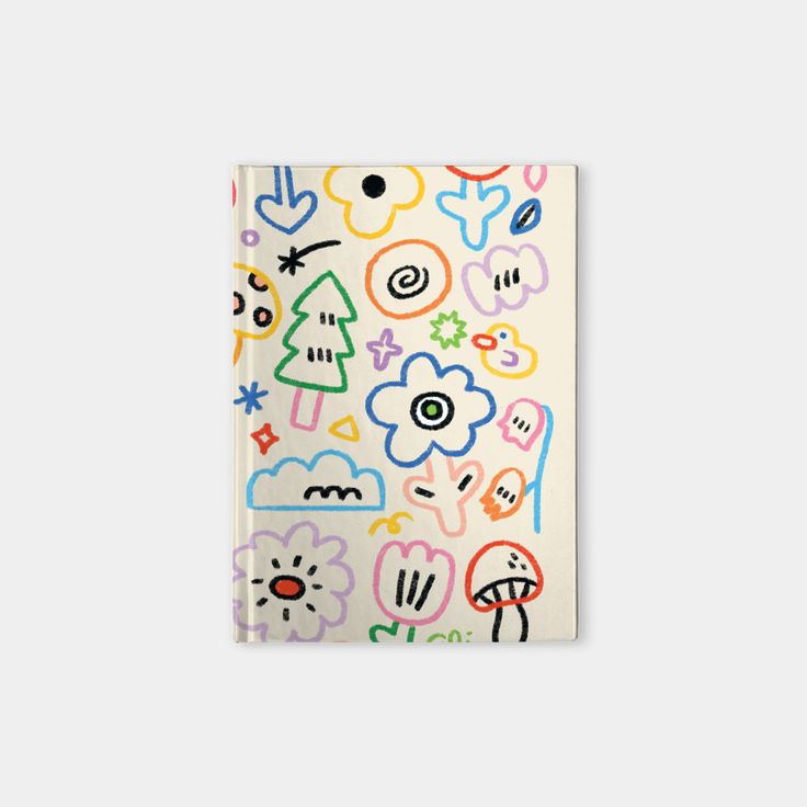 a notebook covered in colorful stickers on top of a white surface with an image of trees and flowers