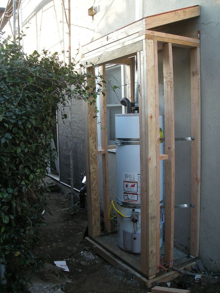 an outdoor water heater is being installed in the back of a house with wood framing around it