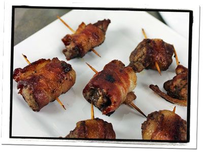 several skewered meats are sitting on a white plate