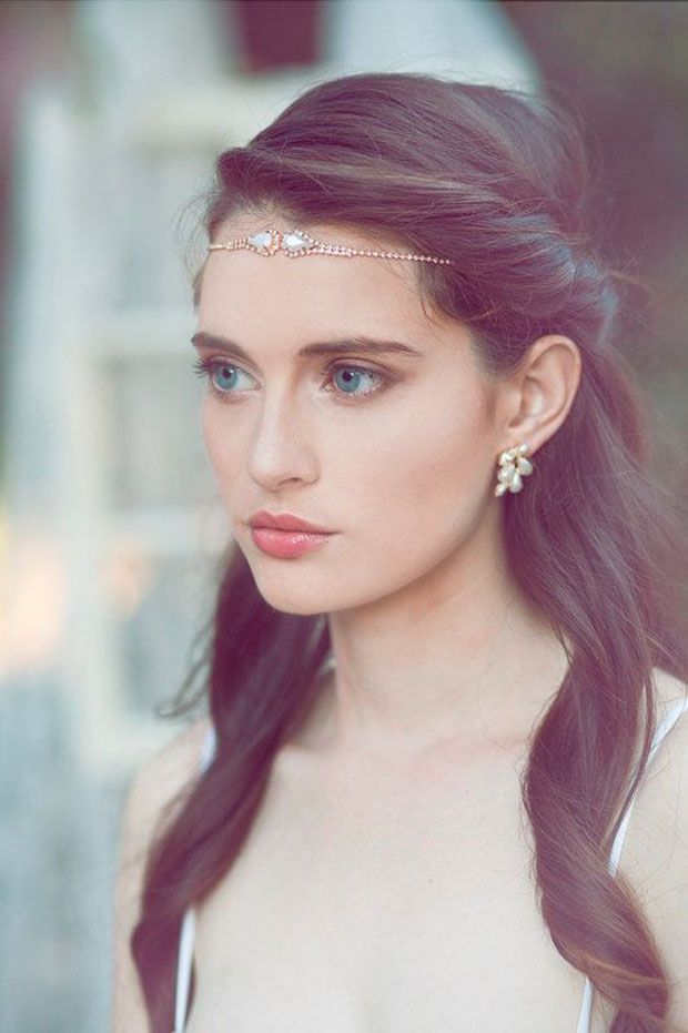 a woman with long dark hair wearing earrings