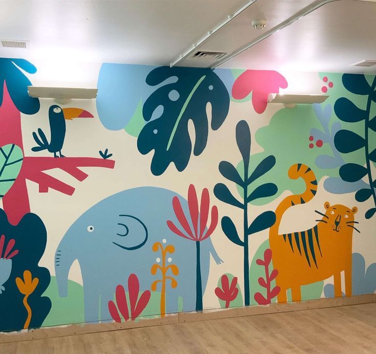 an elephant and tiger mural on the side of a wall in a building with wood flooring