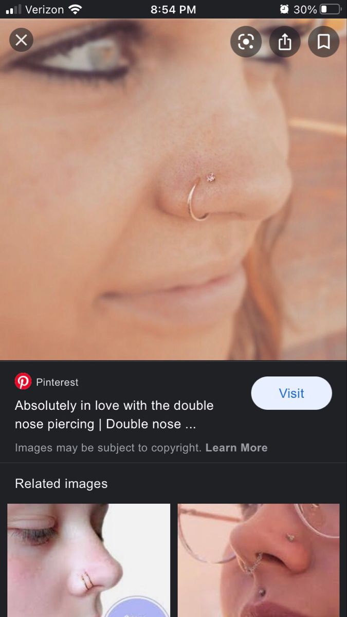 an image of a woman with piercings on her nose and nose ring in the foreground