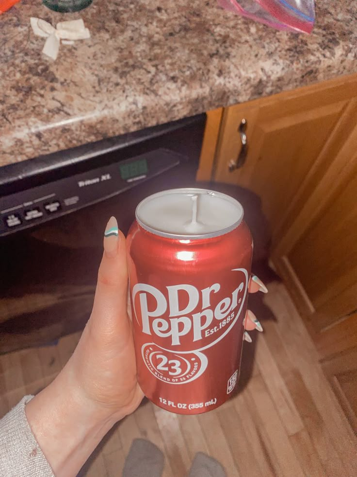 a woman is holding a can of dr pepper