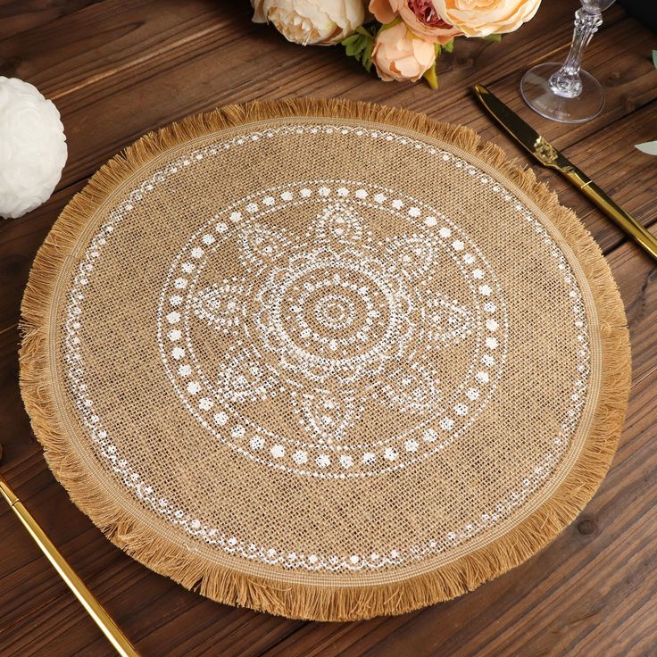 the table is set with gold and white placemats, silverware, and flowers