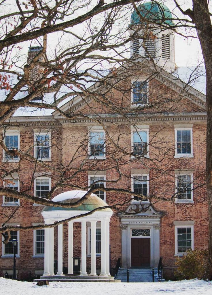 an old brick building with columns in the snow