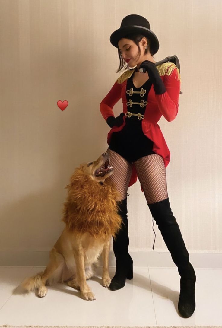 a woman in a costume standing next to a dog