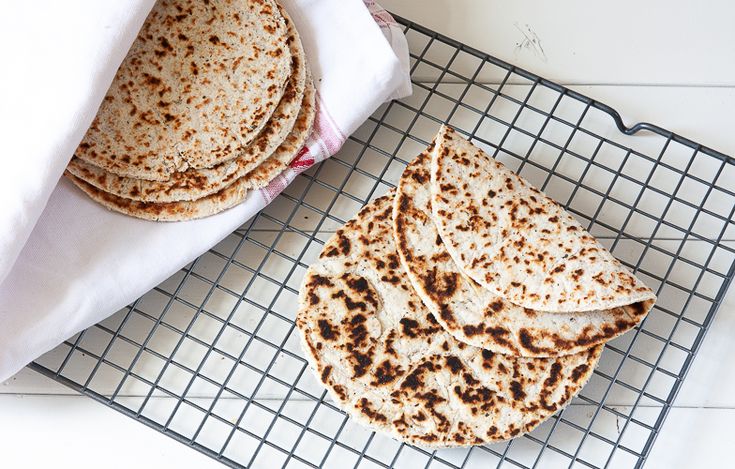 several flat breads are on a cooling rack