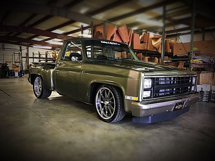 a green truck parked inside of a garage