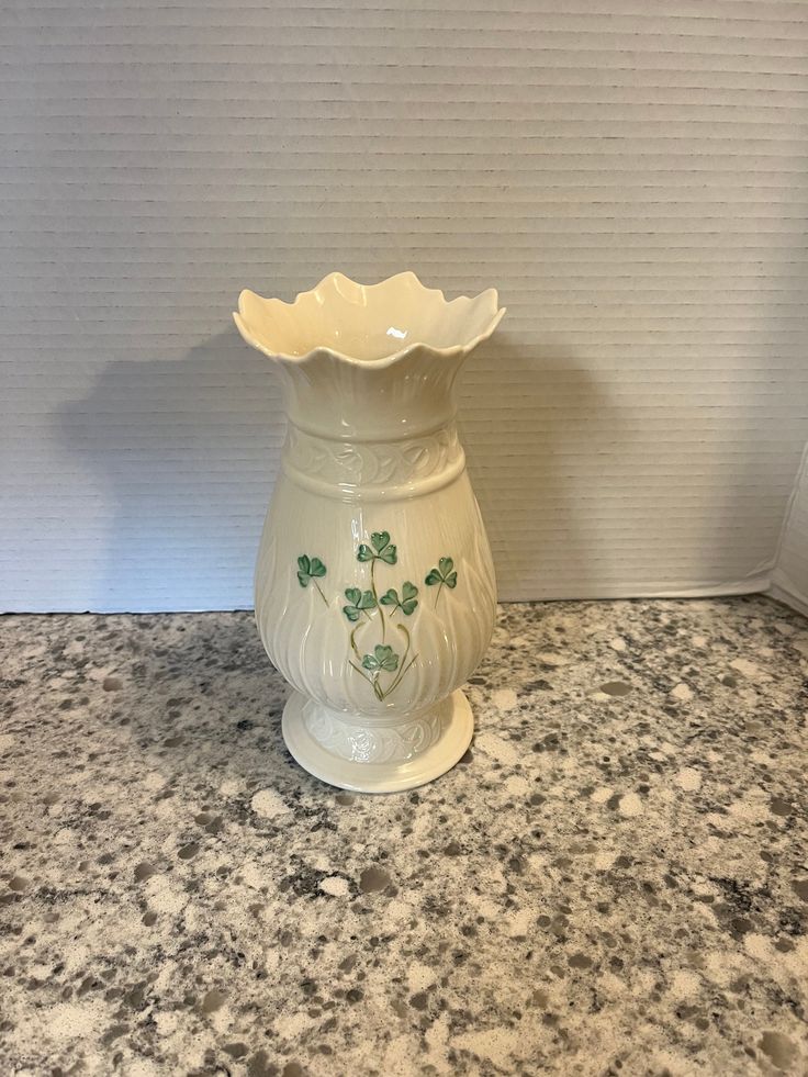 a white vase sitting on top of a marble counter