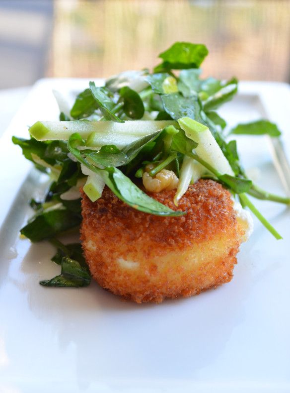 a white plate topped with meat covered in greens