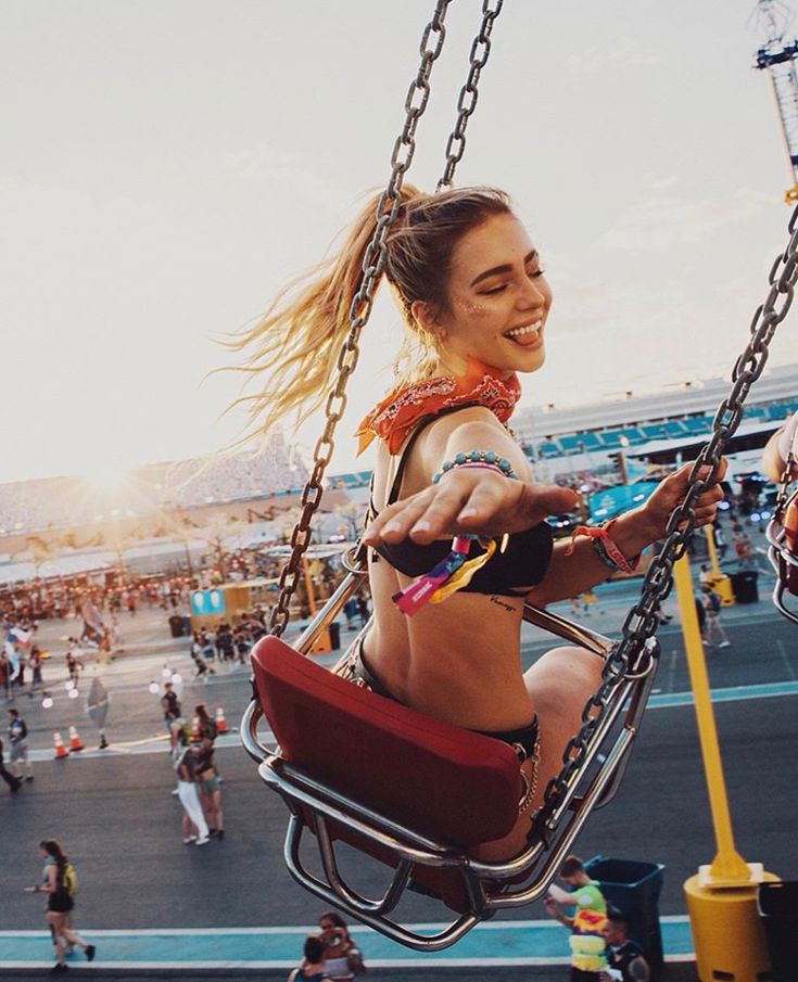 a woman sitting on top of a swing