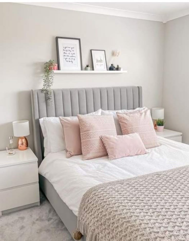 a bedroom with a bed, nightstands and two pictures on the wall above it