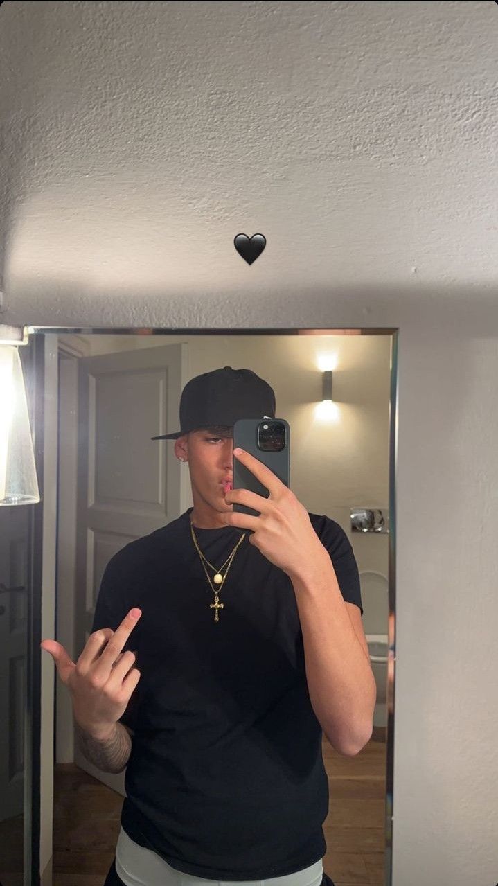 a man taking a selfie in front of a mirror with his hand up to the camera