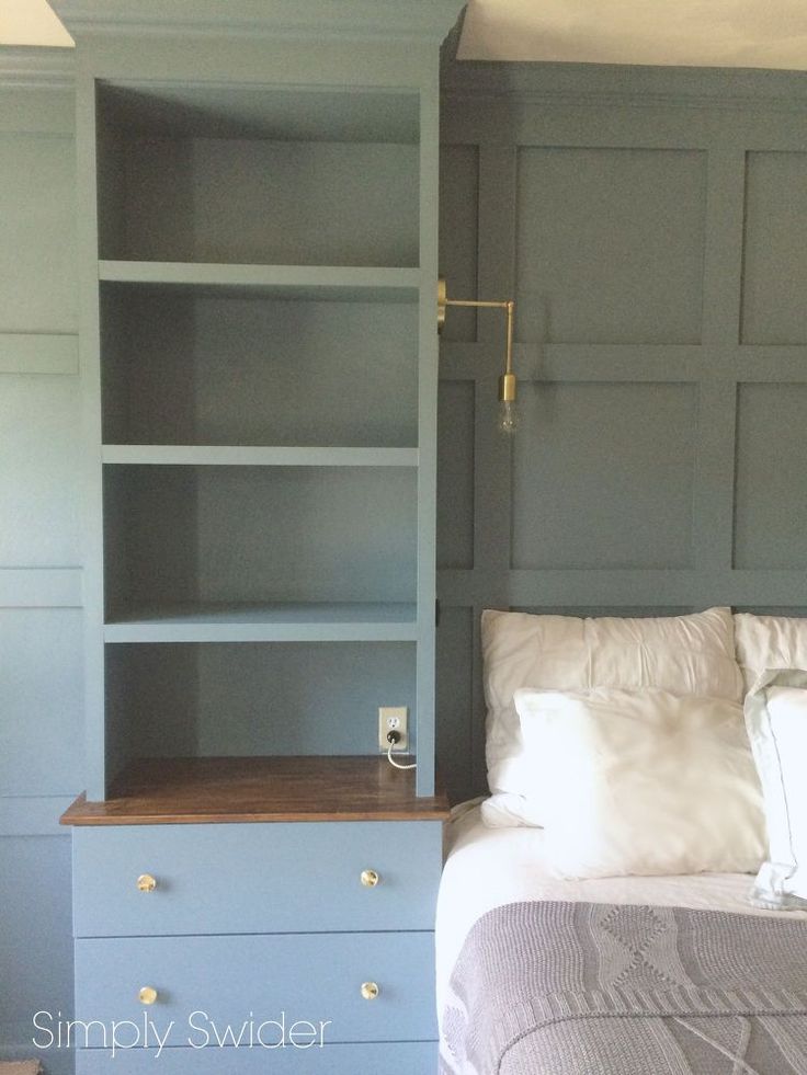 a bedroom with blue bookcases and a white bed