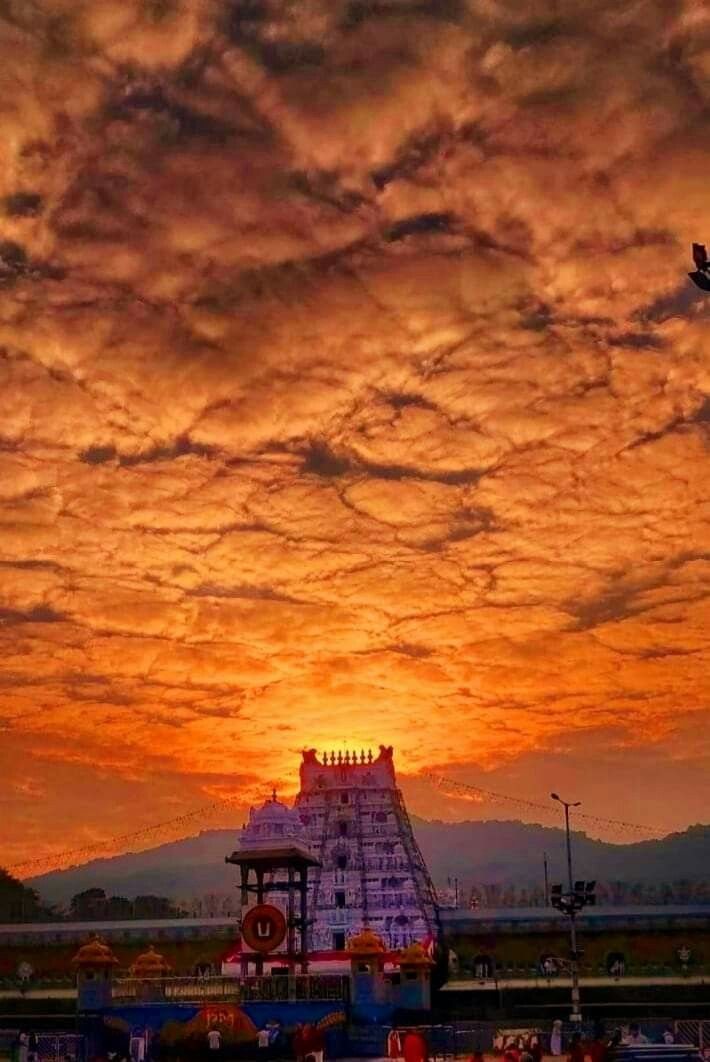 the sun is setting over an amusement park