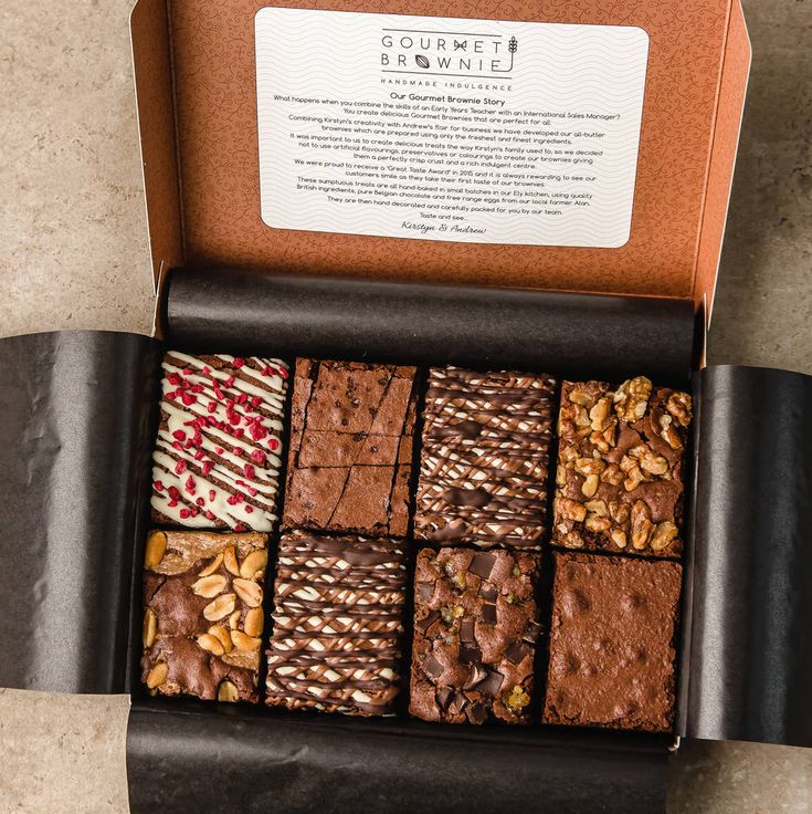 a box filled with assorted brownies and nuts on top of a marble counter