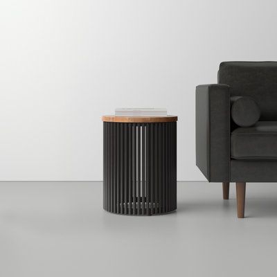 a chair and table sitting next to each other on a gray floor with a white wall in the background