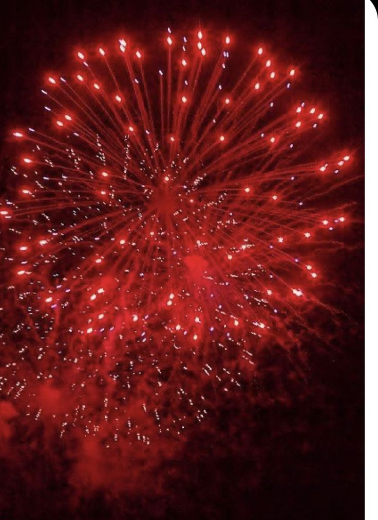 a red fireworks is lit up in the night sky