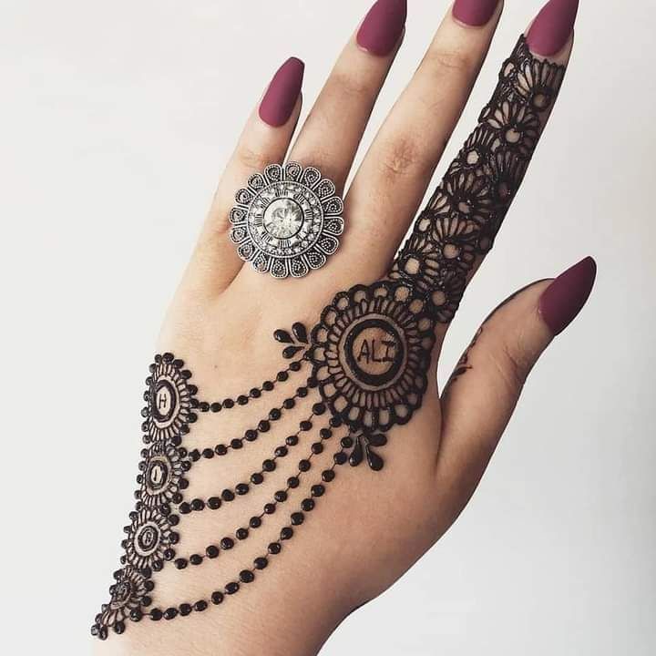 a woman's hand with henna on it and a ring in the middle