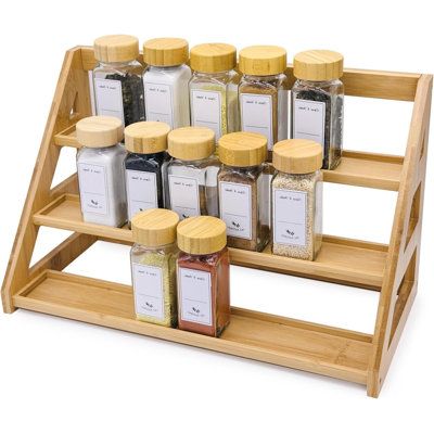 a wooden spice rack with twelve spices on the top and two rows of jars in front