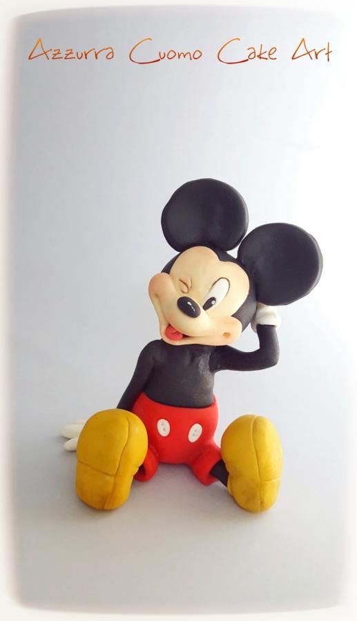 a mickey mouse figurine sitting on top of a white surface with the words azzura comp cafe art above it