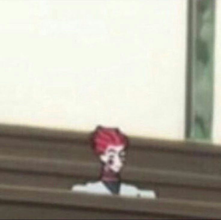 a person with red hair is sitting on a bench and looking at something in the distance