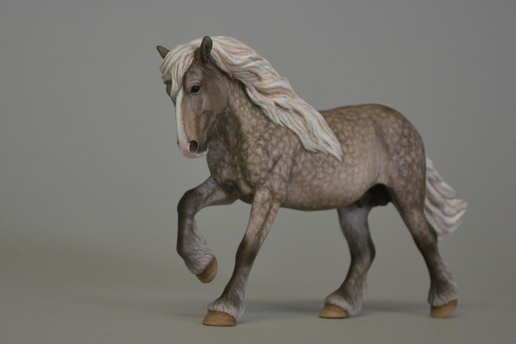 a toy horse that is standing on its hind legs and it's hair blowing in the wind