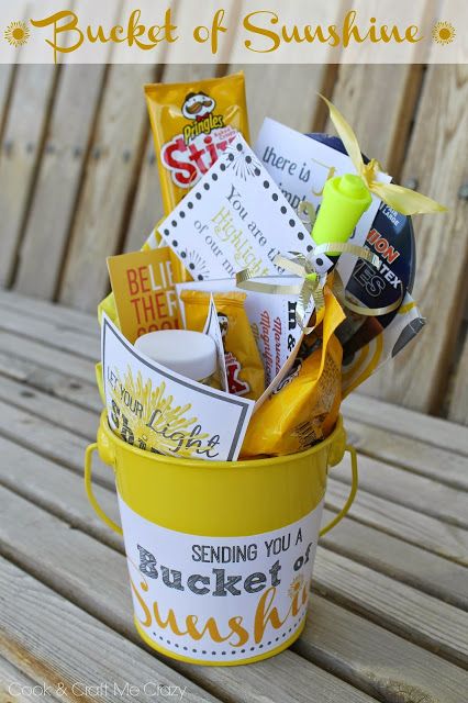 a bucket filled with snacks sitting on top of a wooden table next to a fence