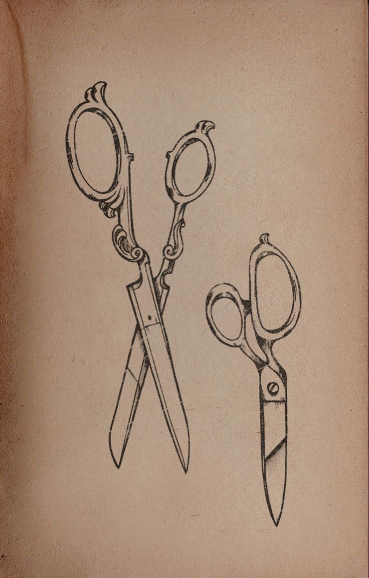 two pairs of scissors sitting next to each other on top of a piece of paper