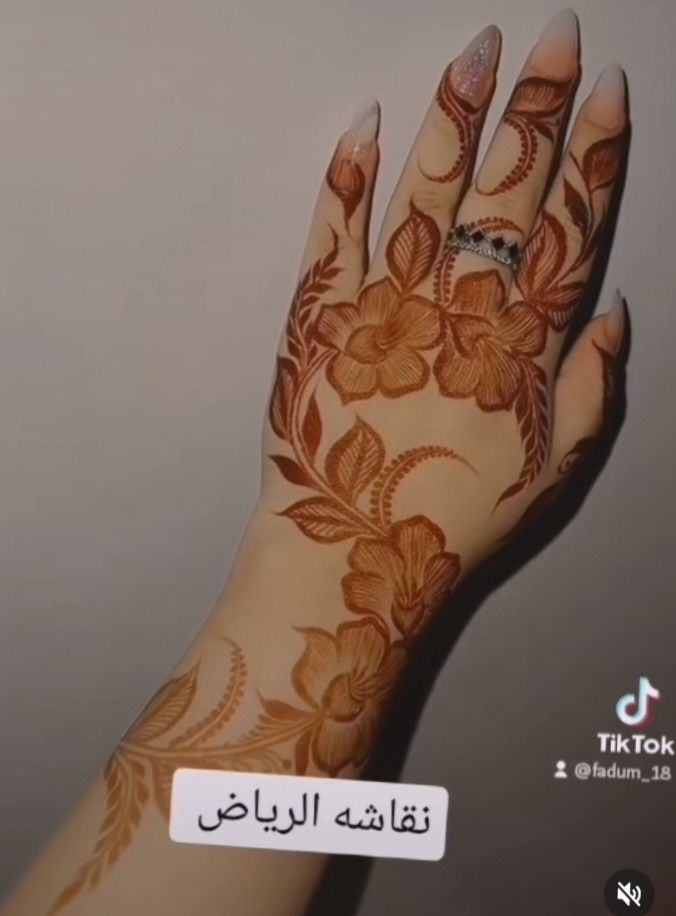 a woman's hand with henna tattoos on it and the words tiktok written in arabic