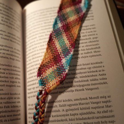 an open book with a colorful bracelet on it