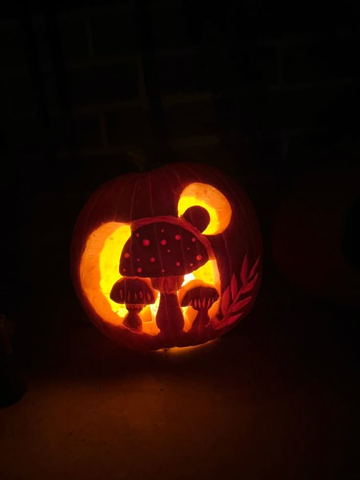 a pumpkin carved to look like it has mushrooms on it and is lit up in the dark