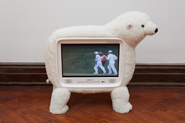 a stuffed polar bear is standing in front of a television