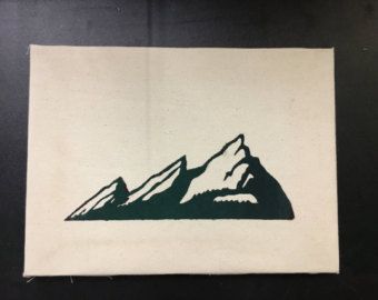 a black and white drawing of mountains on a piece of paper that is sitting on a table