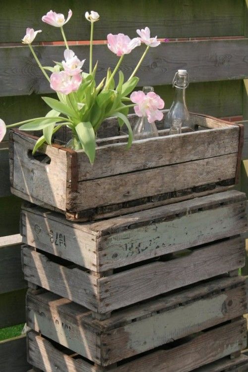 a stack of wooden pallets with flowers in them