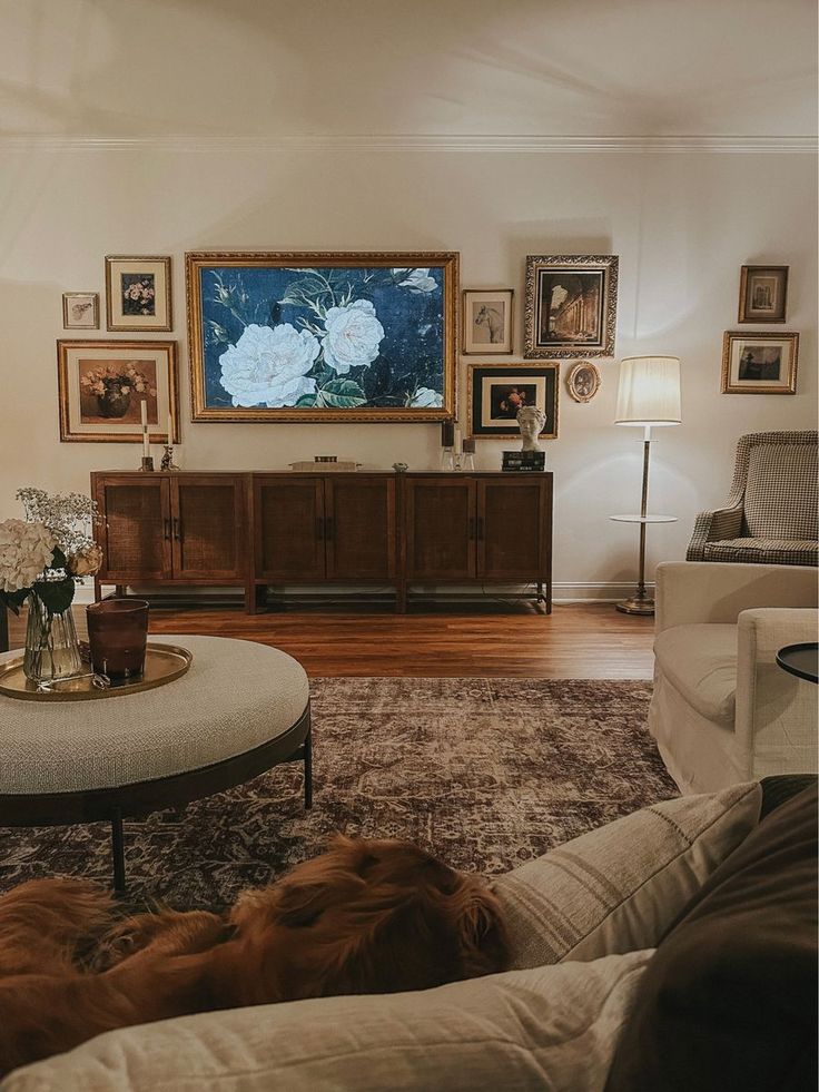 a living room filled with furniture and pictures on the wall over a coffee table in front of a tv