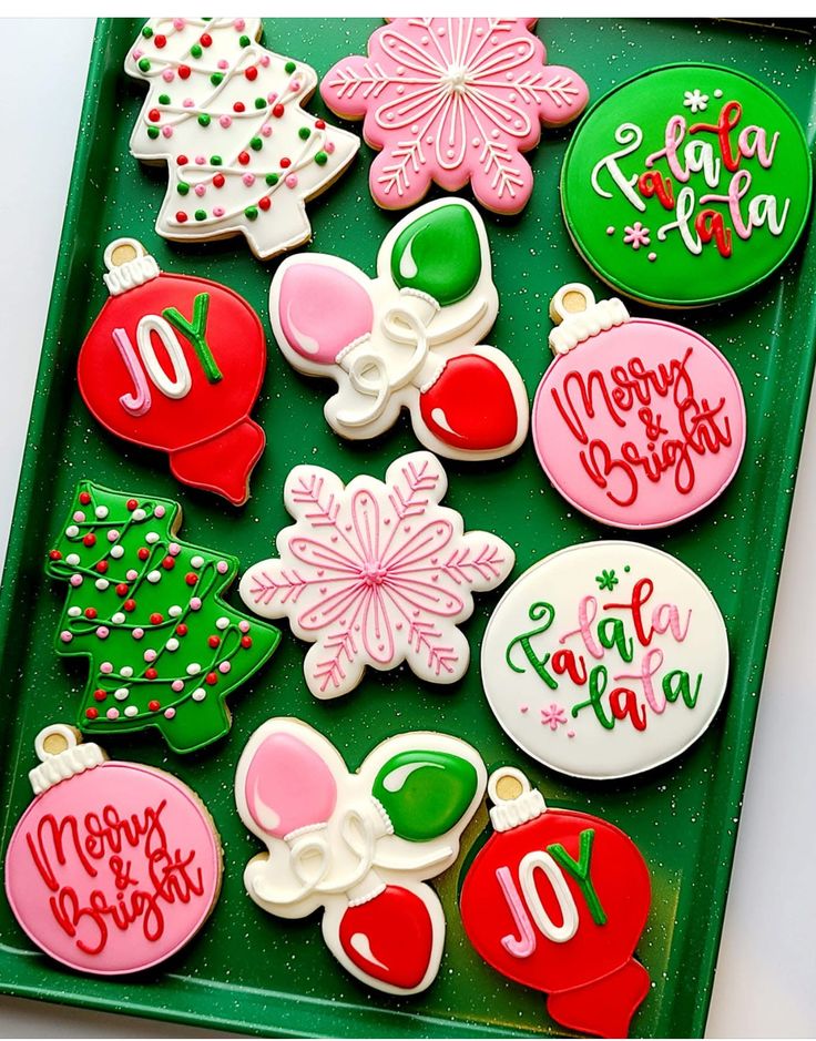 decorated christmas cookies are on a green tray