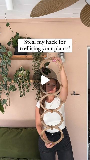 a woman holding up a sign that says steal my back for trellising your plants