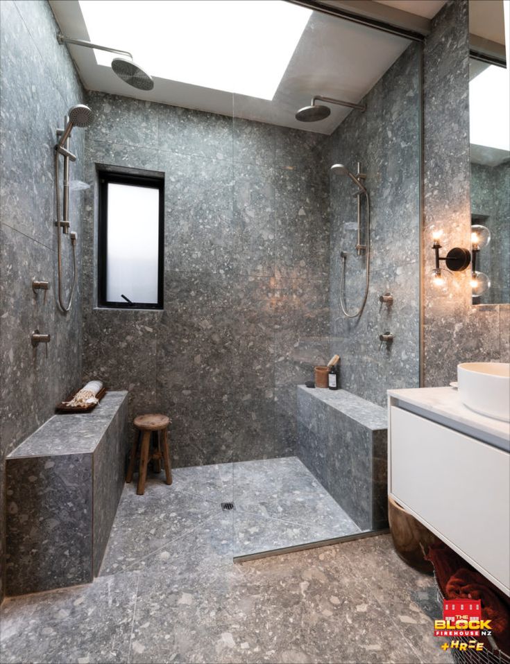 a bathroom with a large walk in shower next to a sink and a mirror on the wall