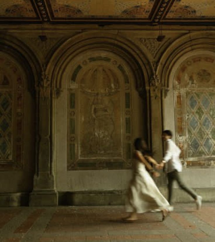 two people are walking in an old building