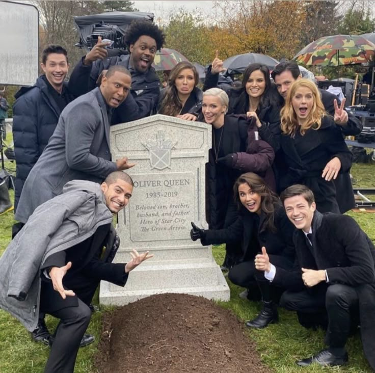 a group of people posing in front of a grave