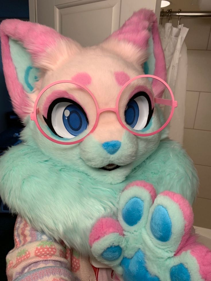 a close up of a stuffed animal with glasses on it's head and paws