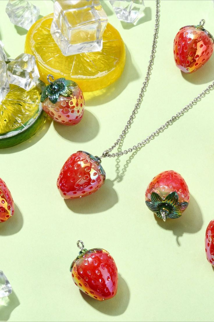 the strawberry necklace is next to some fruit