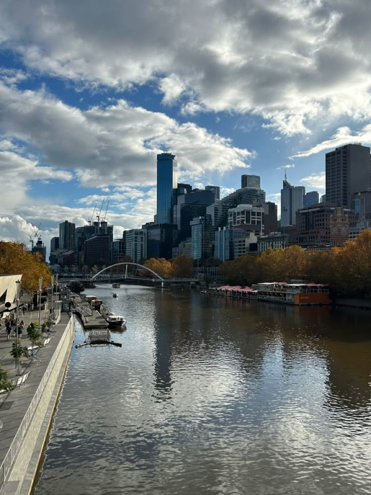 a river with boats on it and tall buildings in the background