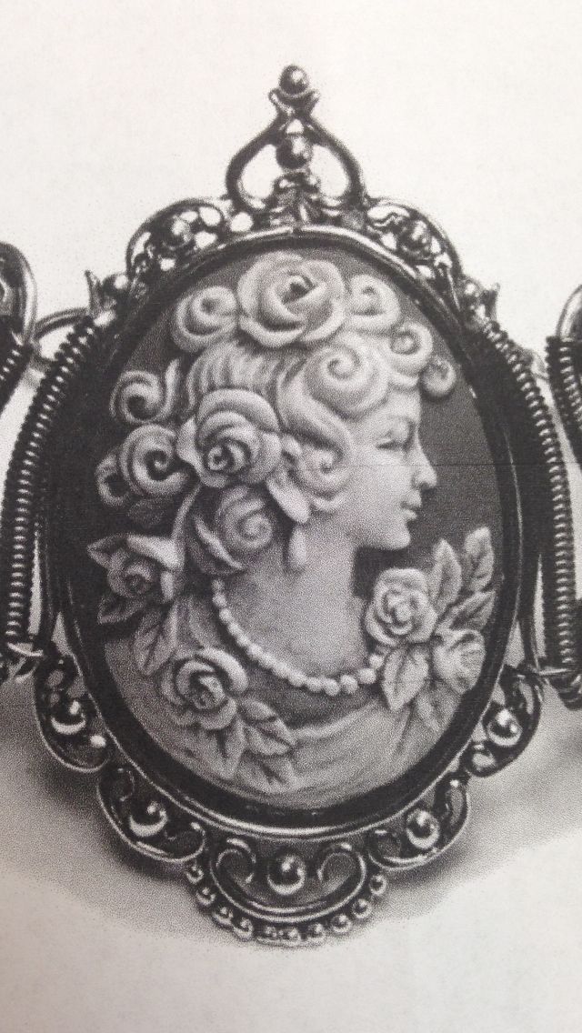 an old photo of a woman's face with roses in her hair is hanging on a chain