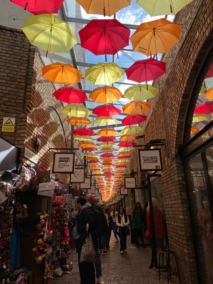 many umbrellas hanging from the ceiling in a market