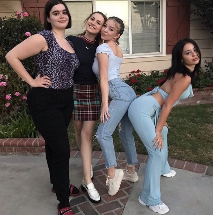 three women are posing for the camera in front of a house with their hands on their hipss