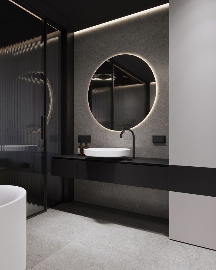 a black and white bathroom with a round mirror