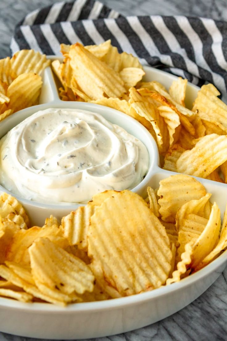 a white bowl filled with chips and dip